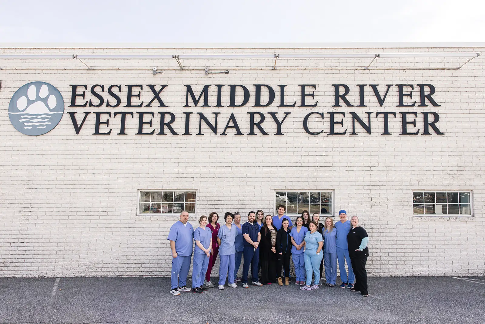The Essex Middle River Veterinary Center team poses outside underneath the vet clinic sign.